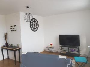 - un salon avec un canapé et un réveil sur le mur dans l'établissement Superbe appartement de 41m2 en résidence privé, à Fleury-les-Aubrais