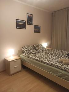a bedroom with a bed and two lamps on a night stand at Apartament za rogiem Papierni in Duszniki Zdrój