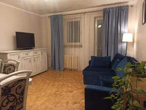 a living room with a blue couch and a tv at Apartament za rogiem Papierni in Duszniki Zdrój