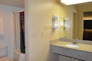 a bathroom with a sink and a mirror at Delux Inn Tulsa in Tulsa