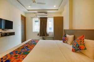 1 dormitorio con 1 cama grande y TV en FabHotel Champion Gateway, en Bangalore