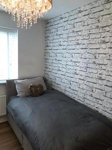 a bedroom with a brick wall and a bed at Double room with en-suite. Central for North West in Rainhull