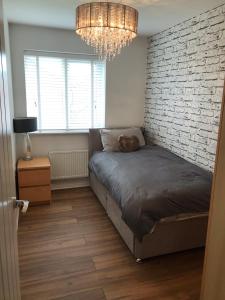 a bedroom with a bed and a brick wall at Double room with en-suite. Central for North West in Rainhull