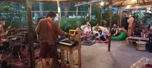 een man die voor een podium staat met een groep mensen bij Red Monkeys Hostel in Arambol