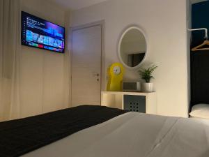 サン・ペッレグリーノ・テルメにあるDesign Suite Cavagnaのベッドルーム1室(ベッド1台、壁掛けテレビ付)