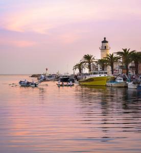 a group of boats in the water near a lighthouse at COTE PLAGE HYPER CENTRE - Bord de mer in Le Grau-du-Roi +32 photos