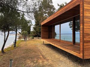 a wooden house on the beach with a large window at iHouse Nea Skioni in Nea Skioni