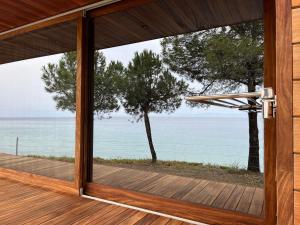 an open door to a deck with a view of the water at iHouse Nea Skioni in Nea Skioni