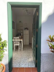 una puerta verde que conduce a una cocina con mesa en Vivienda Vacacional Juliana, en Valle Gran Rey