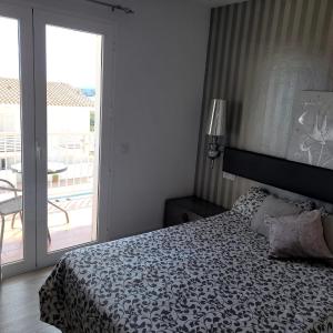 a bedroom with a bed and a balcony with a table at Des Artistes Son Parc in Son Parc +19 photos