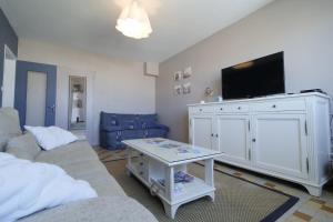 a living room with a couch and a tv at Une grande maison pour 10 proche de la mer in Saint-Gilles-Croix-de-Vie