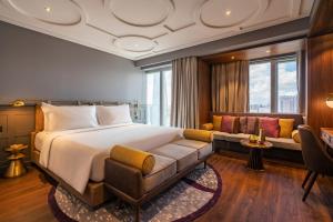 um quarto de hotel com uma cama e um sofá em Fusion Original Saigon Centre em Cidade de Ho Chi Minh