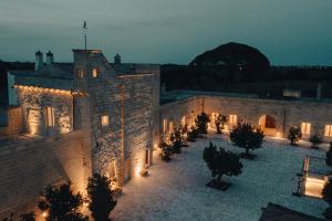 an old building with a courtyard at night at MASSERIA LILEI in Lizzanello