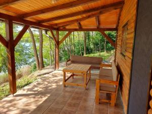 eine Terrasse mit einer Bank, einem Tisch und einem Stuhl in der Unterkunft Vikendica in Erdevik