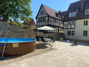 um pátio com uma mesa e um guarda-chuva ao lado de um edifício em Apartment In der Hohen em Quedlinburg