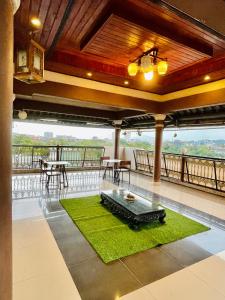 a room with a balcony with a table on the floor at Nam Phương Riverside Villa in Hue