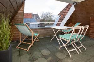 a patio table with chairs and umbrellas at Hotel de Vischpoorte in Deventer