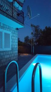 ein Pool in der Nacht mit blauen Lichtern in der Unterkunft Holiday home Goranka in Zmijavci