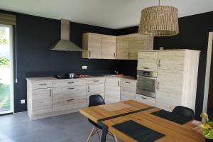 a kitchen with wooden cabinets and a wooden table at "Petite perle en Haute Ardenne" avec vue sur la vallée, cabine infra-rouge et bain balnéo in Lierneux