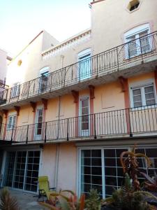 an apartment building with balconies and a green chair at La villa Rosace in Cerbère