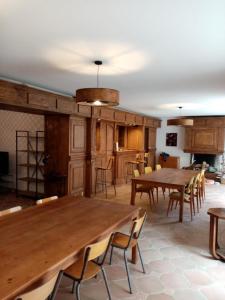 Habitación grande con mesas y sillas de madera. en La villa Rosace en Cerbère