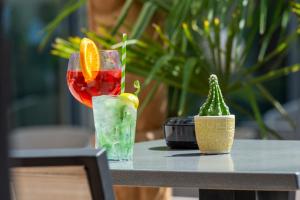 a table with two cocktails and a plant on it at Mercure Toulouse Centre Saint-Georges in Toulouse