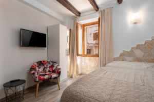 una camera con letto, sedia e televisore di Casa Albina a Rovigno (Rovinj)