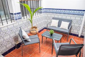 a balcony with two chairs and a table and a plant at Apartamento AGUADULCE in Sanlúcar de Barrameda