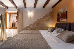 a bed in a room with a stone wall at Casa Albina in Rovinj