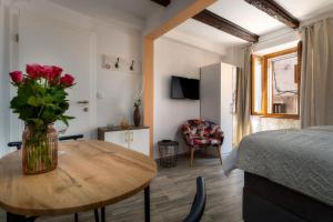 a room with a bed and a table with a vase of roses at Casa Albina in Rovinj