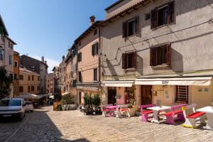 a street with tables and chairs in front of a building at Casa Albina in Rovinj
