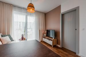a living room with a tv and a window at SuperApart Gdańsk Jasień in Gdańsk