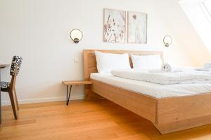 a bedroom with a bed with white sheets and a chair at Nadland Apartments B61 in Vienna