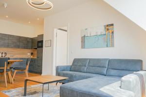 a living room with a blue couch and a table at Nadland Apartments B61 in Vienna