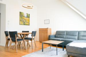 a living room with a couch and a table and chairs at Nadland Apartments B61 in Vienna