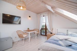 a bedroom with a bed and a desk and a table at Zielone Miejsce - w otoczeniu natury, z balią z jacuzzi opalaną drewnem in Karwia