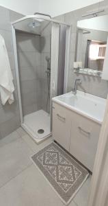 y baño con ducha, lavabo y espejo. en CASA VACANZE DIMORA MONFALCONE, en Montescaglioso