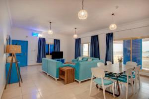 a living room with blue furniture and a table at مراسي الأحلام لبيوت العطلات in Al Lith