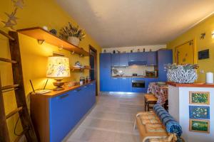a kitchen with blue cabinets and a couch in a room at Rebecca's House few steps from skiing - Happy Rentals in Bardonecchia