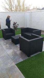 a person standing in a yard with two black benches at Casa de los Maestros in Rágama +4 photos
