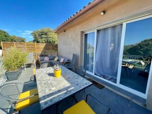 a patio with a table and chairs on a balcony at Case Di A Cappana-Villa CARLA in Bonifacio