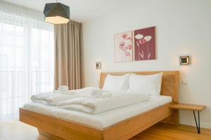 a bedroom with a large bed with white sheets at Nadland Apartments B61 in Vienna