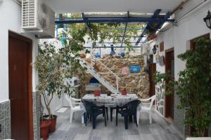a patio with a table and chairs and a stone wall at Hotel Eleftheria in Parikia
