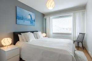 1 dormitorio con cama blanca y ventana en City Holiday Apartments 1 en Rovaniemi