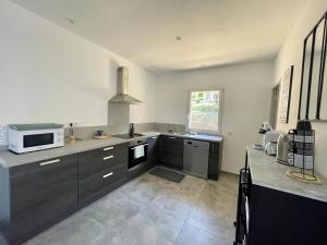 a kitchen with a sink and a microwave at Case Di A Cappana-Villa CARLA in Bonifacio