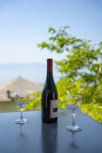 Una botella de vino y dos copas en una mesa. en Pelion house with stunning view to relax, en Vizítsa