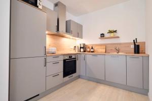 a large white kitchen with white cabinets and appliances at De groode Ünnen in Dollerup