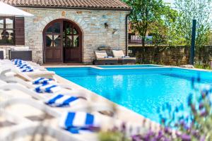a swimming pool with lounge chairs next to a house at Villa Murva in Žminj