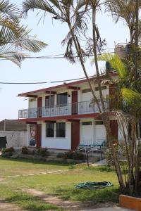 une maison avec des palmiers devant elle dans l'établissement Los Naturales, à Huaral