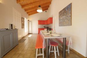 een keuken met rode kasten en een tafel met krukken bij Ensemble, dans une maison avec jardin près de la mer in Brétignolles-sur-Mer